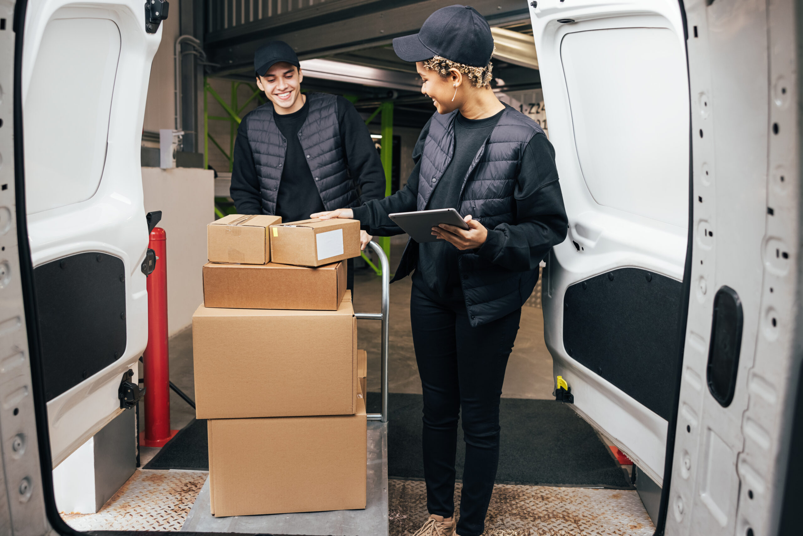 Couriers in uniform working together. People preparing parcels for delivery.