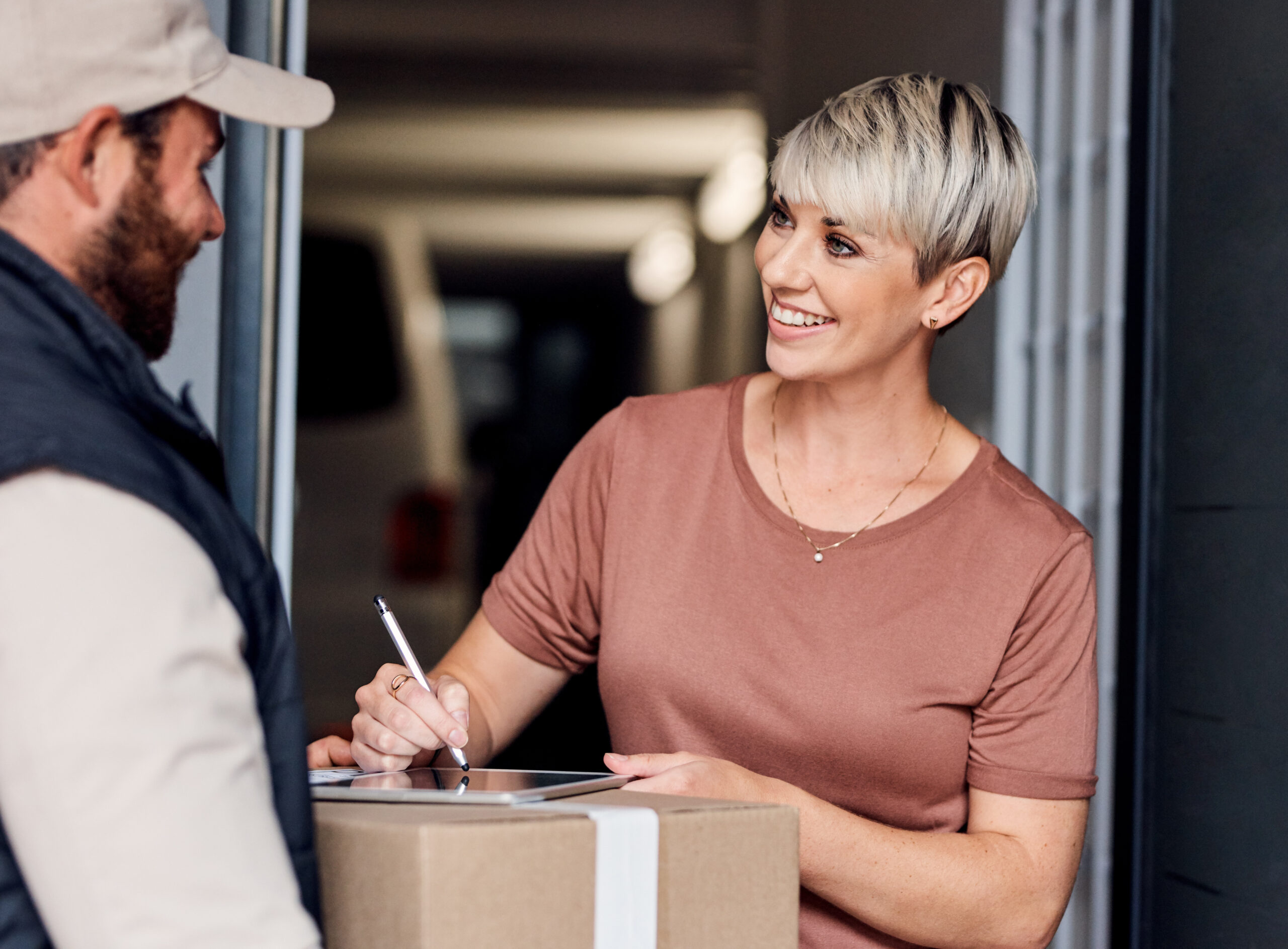 Shot of a young woman signing for a delivery from the courier.